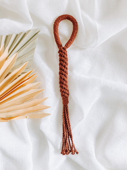 Handmade macrame dog toy in rust full view